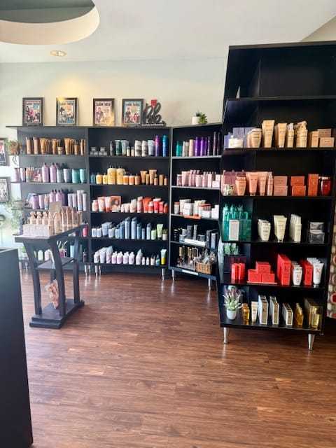 Shelves displaying various hair and skincare products in a modern store with wooden flooring.